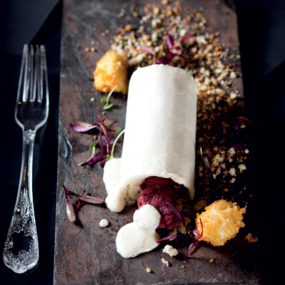 Ostrich tartare with roast garlic and caper foam, Parmesan soil and deep-fried quail egg in a rock salt dome