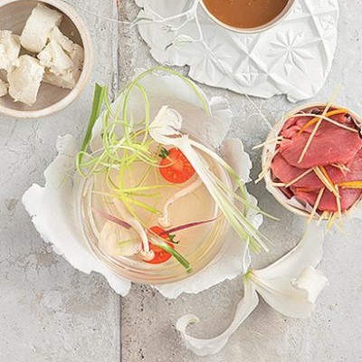 Clear tomato soup with shaved beef and vegetables