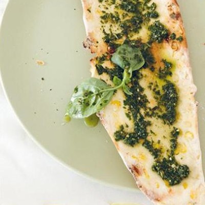 Crisp corn flatbread slathered in basil pesto