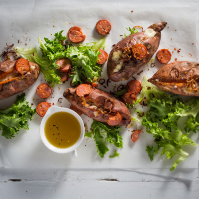 Twice-baked sweet potatoes with spicy sausage, bitter greens and crispy shallots