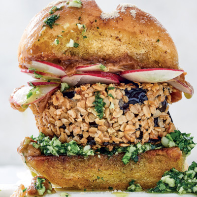 Oat-crumbed spicy brinjal burger with peanut satay-sauce and coconut-coriander pesto