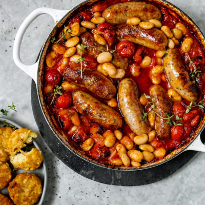 Sausage, butter bean and tomato tray bake with crispy röstis