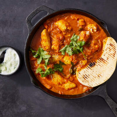 Mild hake curry with flatbreads and raita