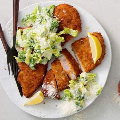 Crumbed pork chops topped with Caesar salad